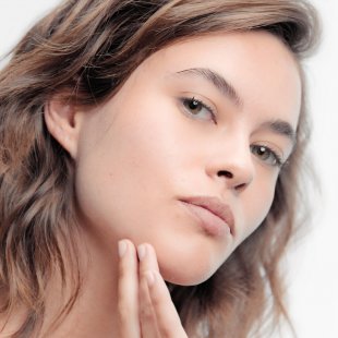 Mujer aplicando se crema facial bioderma Mujer aplicando se crema facial bioderma